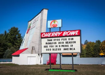 Pantalla del autocine Cherry Bowl con coches al atardecer