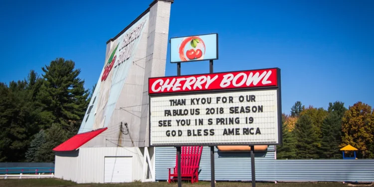 Pantalla del autocine Cherry Bowl con coches al atardecer