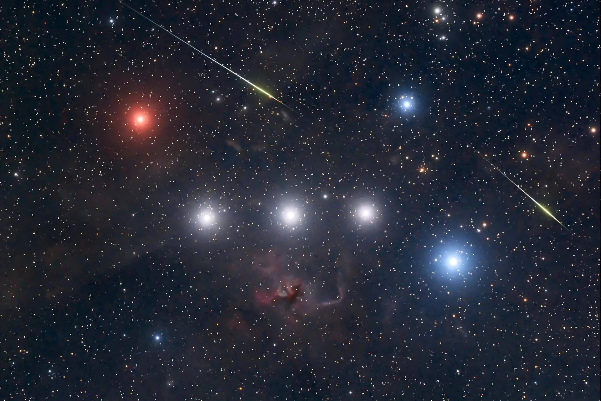 Constelación de Orión con meteoros cruzando el cielo nocturno