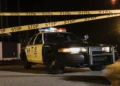 Auto de policía con cinta de precaución de noche