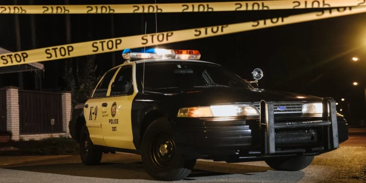 Auto de policía con cinta de precaución de noche