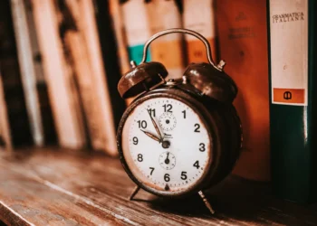 Reloj despertador antiguo sobre una estantería de libros