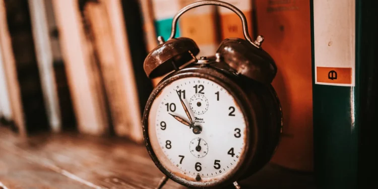 Reloj despertador antiguo sobre una estantería de libros