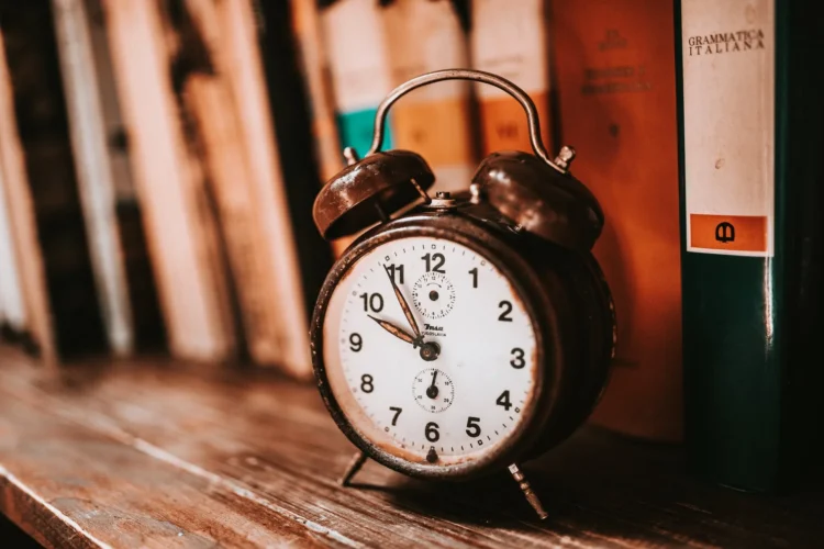 Reloj despertador antiguo sobre una estantería de libros